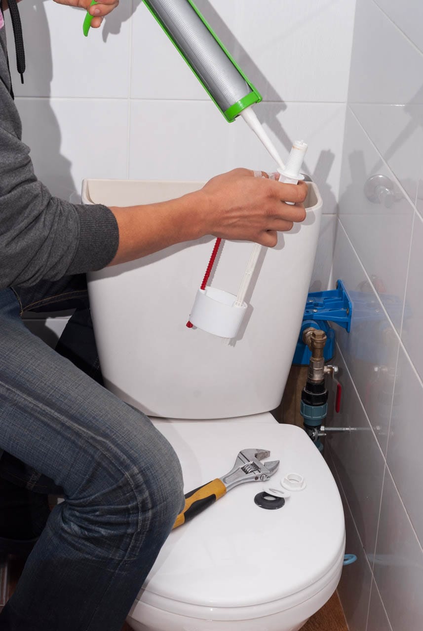 Toilet Repair & Installation 1 Person expertly handling toilet repair installation in a bathroom, using tools and sealant to ensure everything functions perfectly.